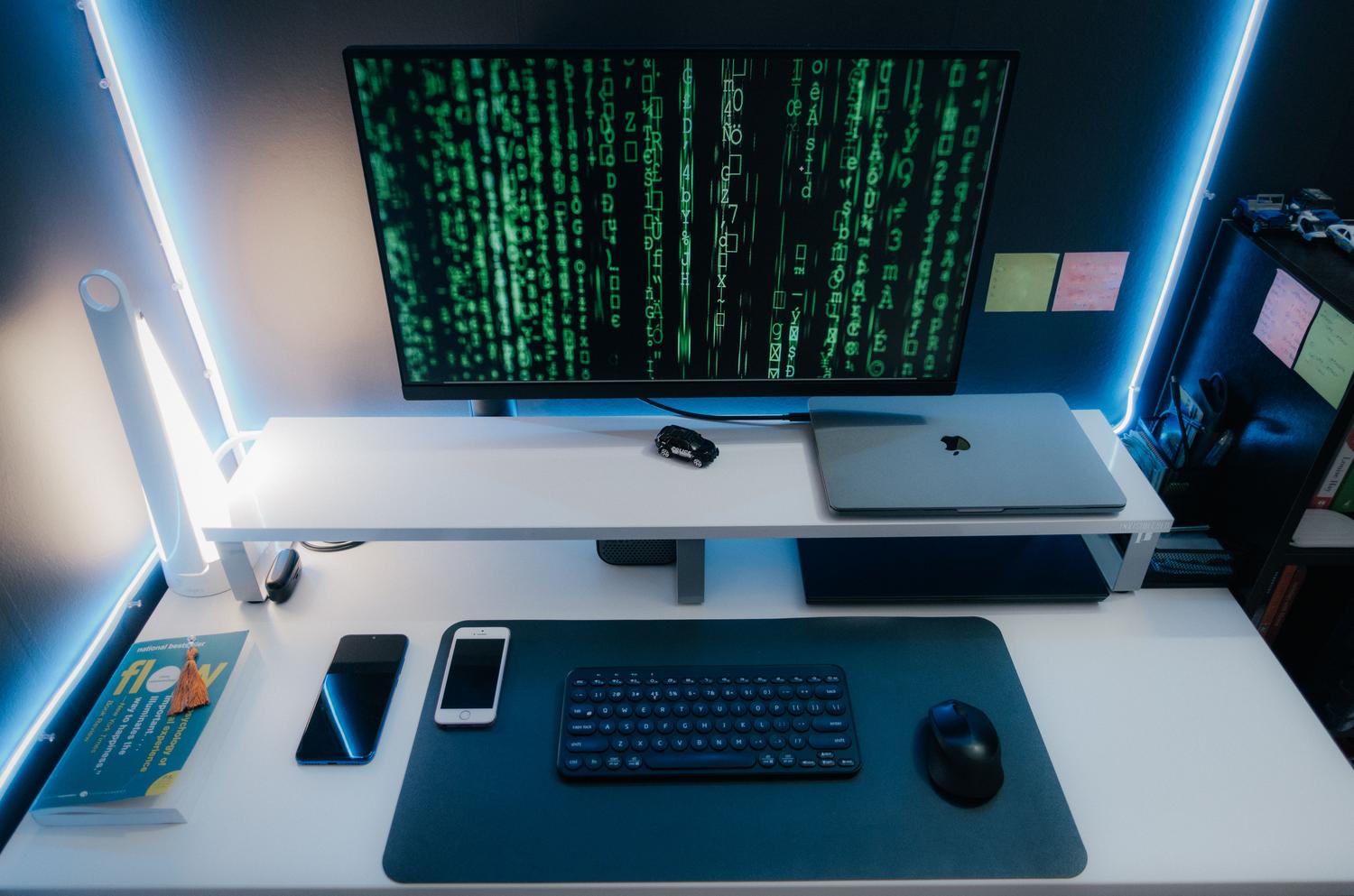 Espacio de trabajo tecnológico con pantalla de código y ambiente futurista con luces LED azules.