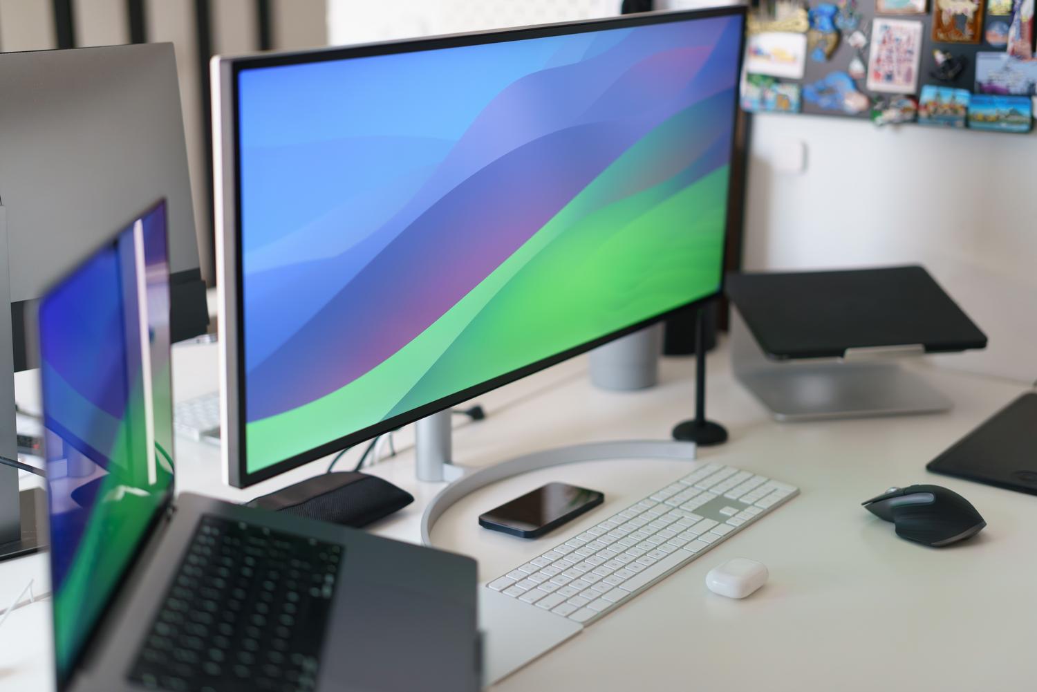 Setup profesional de oficina en casa con monitor ultra ancho, ideal para flujos de trabajo de IA y multitarea.