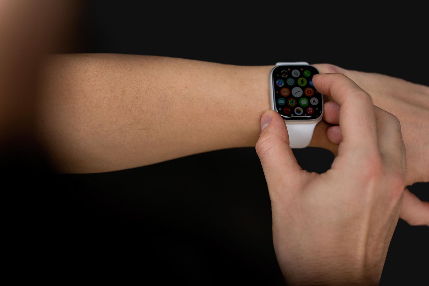 Usuario interactuando con la pantalla brillante y colorida de un smartwatch en estado interactivo.