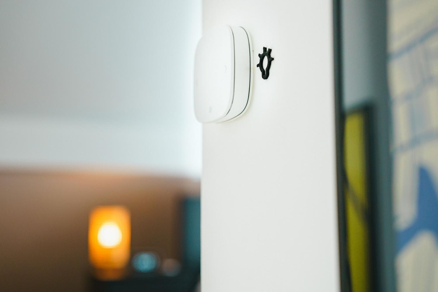 Interruptor de luz inteligente moderno instalado en una pared blanca con ambiente hogareño cálido