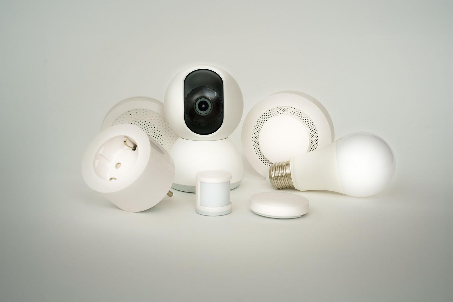 Colección de dispositivos domóticos sencillos: bombilla inteligente, enchufe y sensores en color blanco minimalista