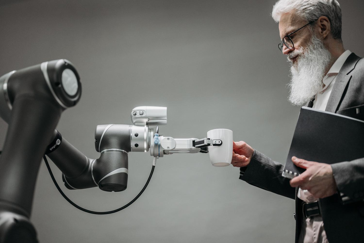 Brazo robótico colaborativo entregando un café a un profesional, simbolizando la automatización inteligente y la sinergia entre el talento humano y la inteligencia artificial.