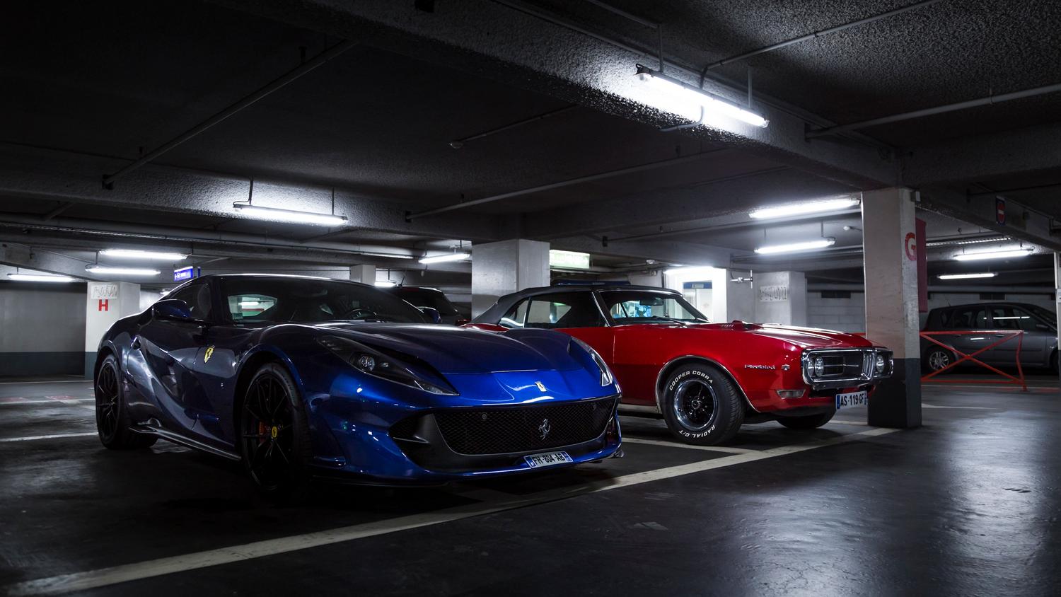 Coches de lujo estacionados en un garaje moderno, evocando el estilo de vida de las organizaciones de GTA Online.