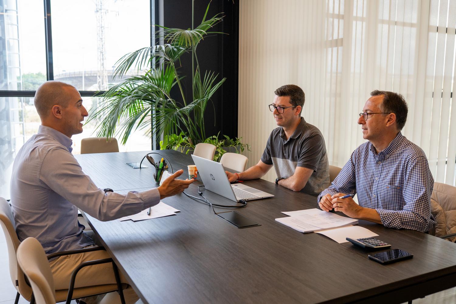 Equipo de profesionales en una reunión de estrategia analizando la rentabilidad y el retorno de inversión de la tecnología.