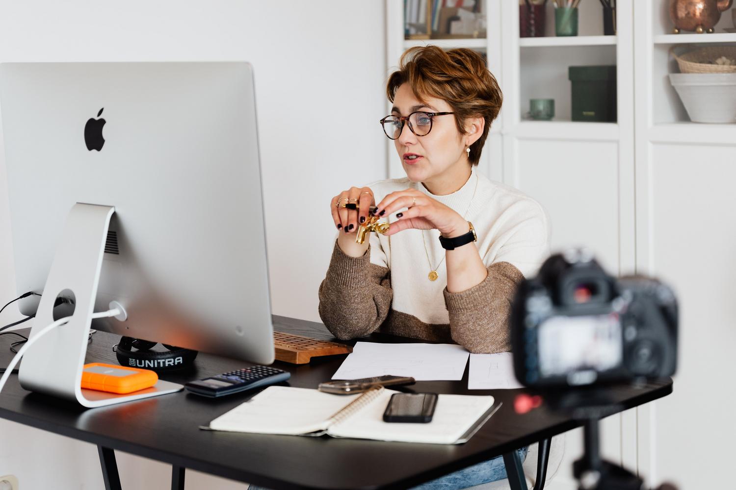 Mentora profesional realizando un webinar online para su microaudiencia desde su estudio.