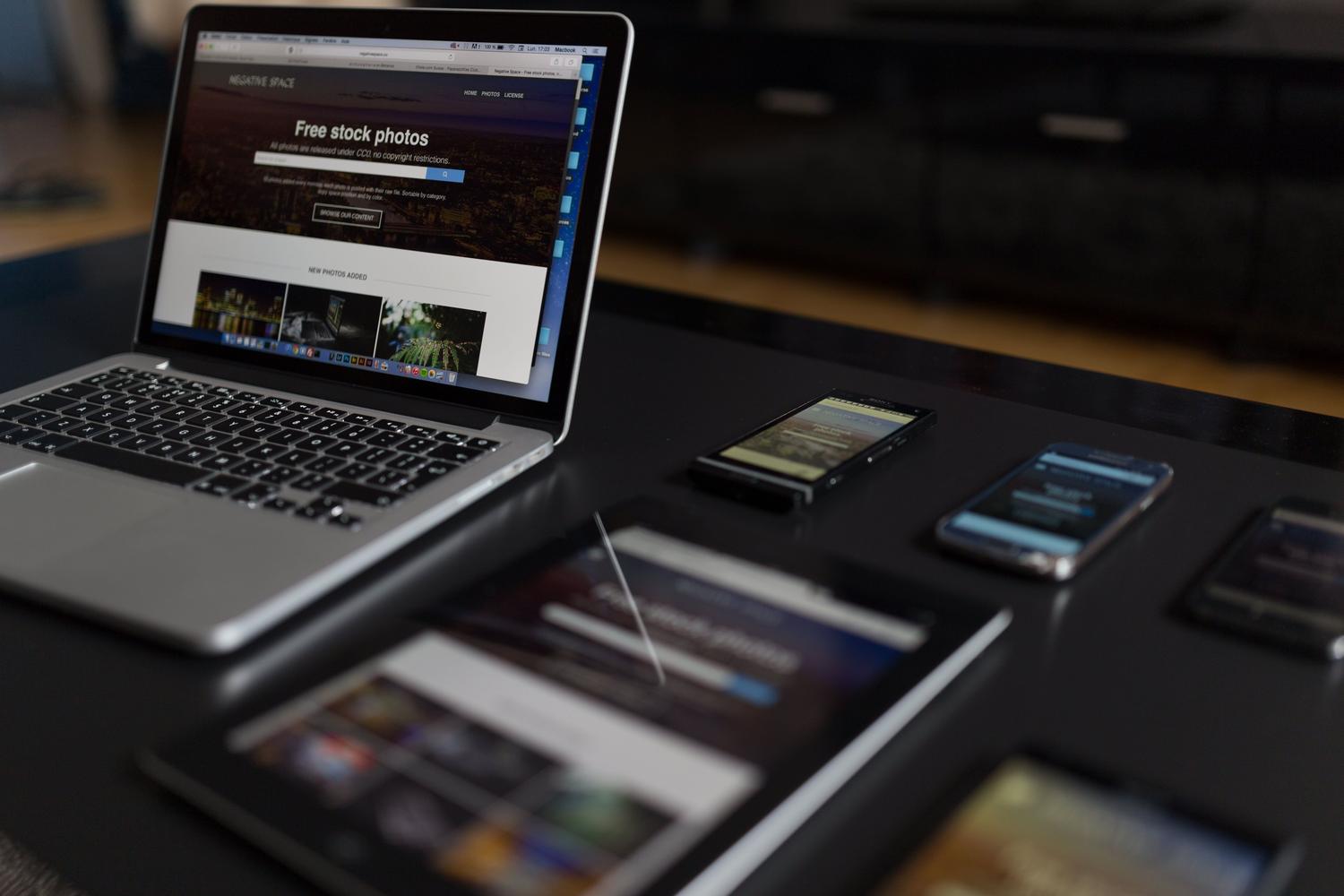 Espacio de trabajo tecnológico con portátil, tablet y móvil, ilustrando la conectividad y el ecosistema de dispositivos.