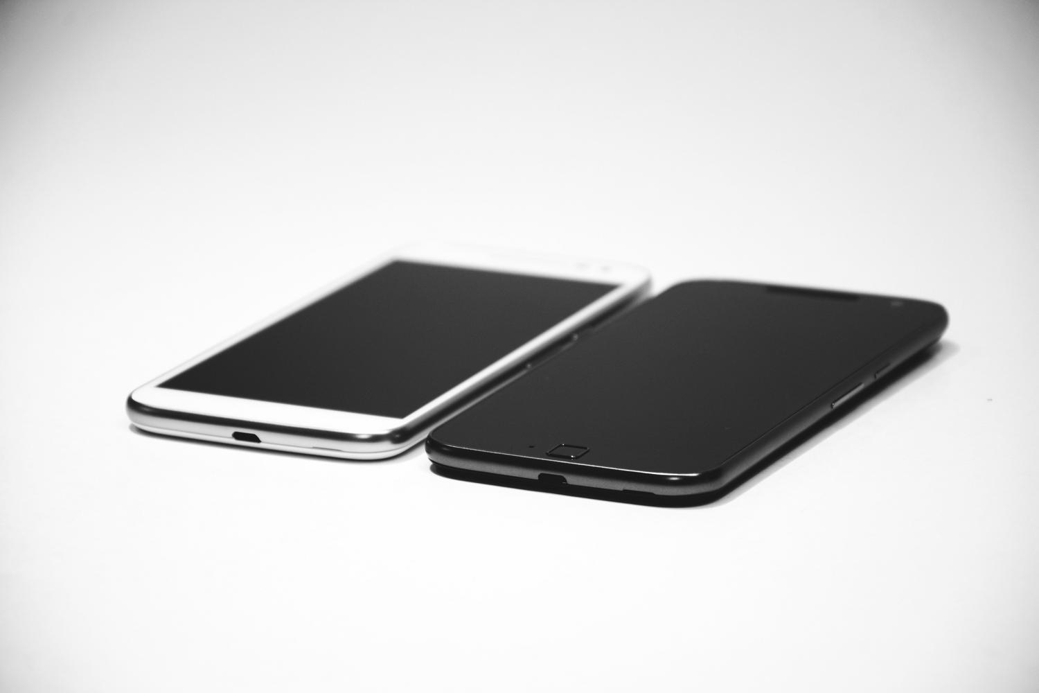 Dos smartphones, uno blanco y otro negro, colocados uno al lado del otro sobre una superficie blanca, representando la conexión directa entre dos dispositivos.