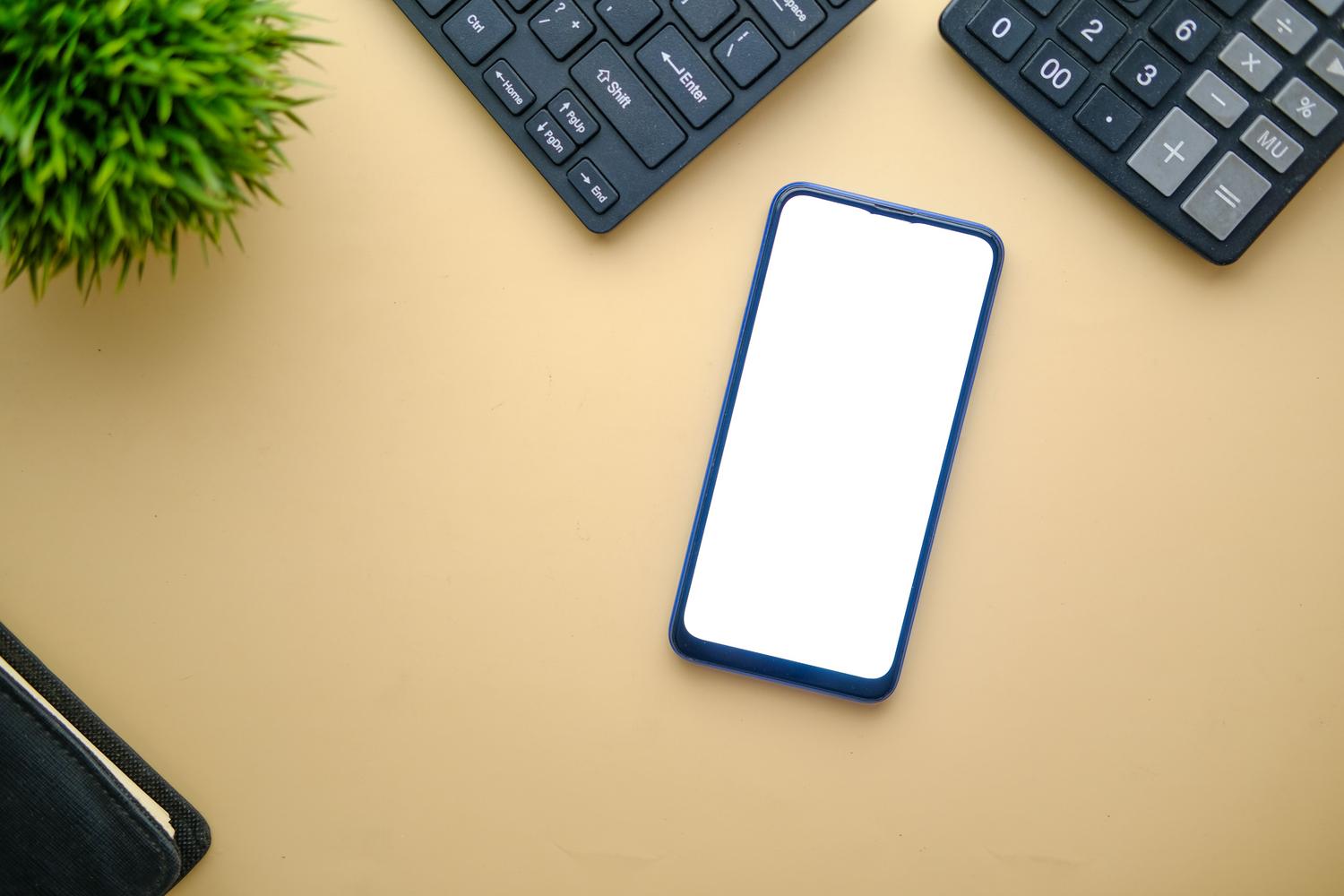 Vista cenital minimalista de un smartphone Android sobre un escritorio limpio, representando el dispositivo final donde se despliega la compilación.
