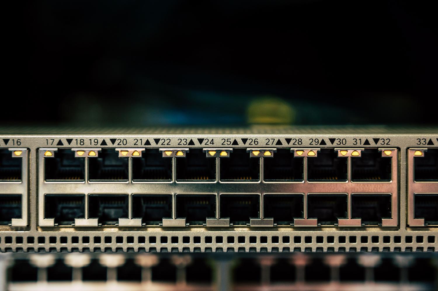 Primer plano detallado de un switch de red con múltiples puertos Ethernet e indicadores LED.