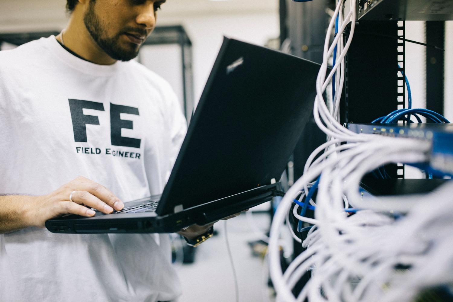 Ingeniero de redes configurando hardware mediante un ordenador portátil.