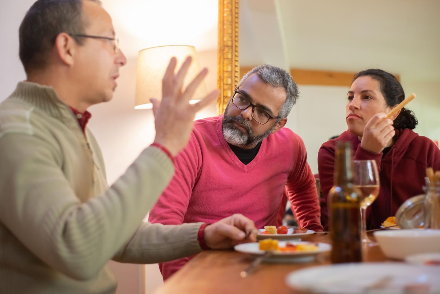 Familia manteniendo una conversación cercana durante una comida, representando la transparencia y el diálogo sobre los límites digitales.
