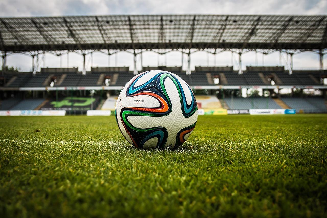 Balón de fútbol en el césped de un estadio, aportando contexto deportivo general al contenido.