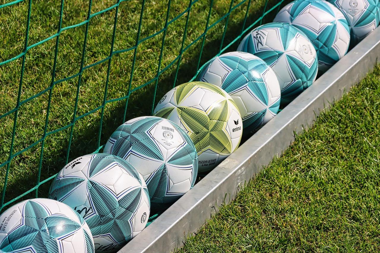 Fila de balones de fútbol alineados, metáfora visual de la creación y gestión de una plantilla en SBC. Fila de balones de fútbol alineados, metáfora visual de la creación y gestión de una plantilla en SBC.