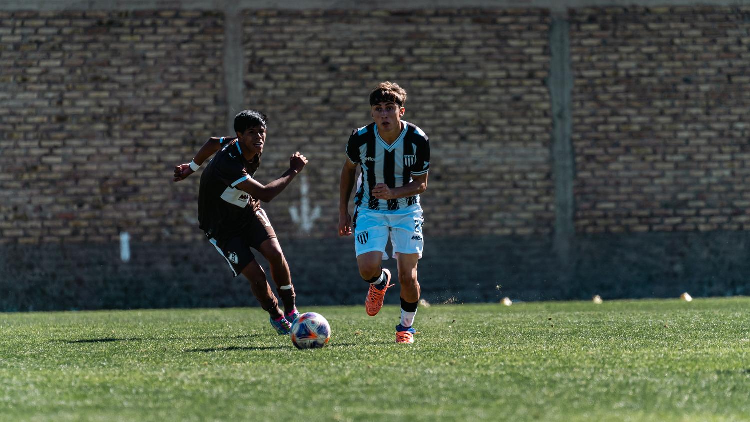 Jugadores de fútbol en plena acción durante un partido competitivo en el campo de césped