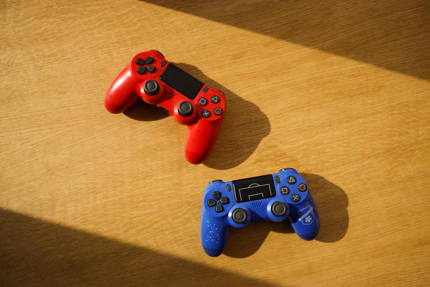 Mandos de videojuegos sobre una superficie de madera, representando el setup de juego para EA FC 27