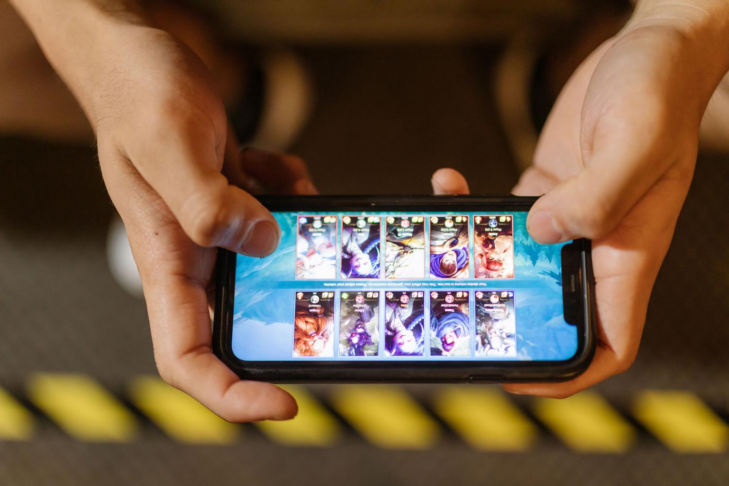 Primer plano de manos configurando un juego en un smartphone, ideal para ilustrar la sección de guía de instalación y ajustes técnicos.