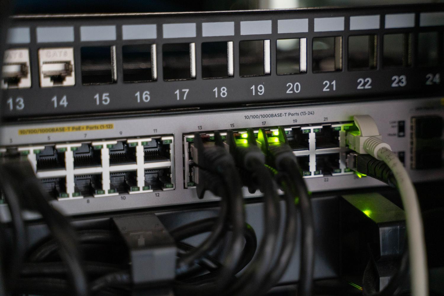 Primer plano de cables de red conectados a un dispositivo de comunicaciones, destacando la conectividad física requerida para el almacenamiento compartido.