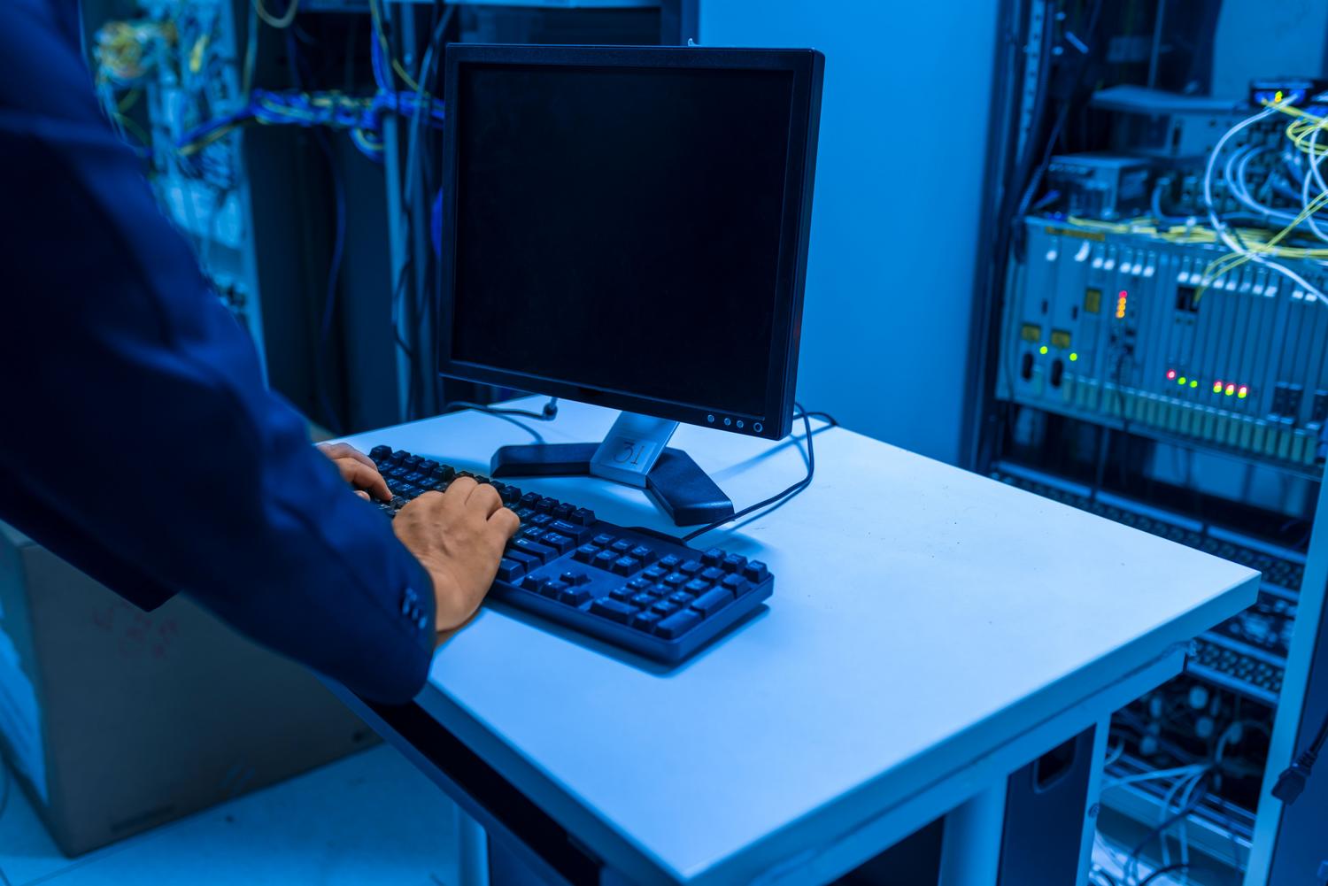 Técnico de IT configurando sistemas de red en una sala de servidores, ilustrando el proceso de administración y mapeo de unidades de red.