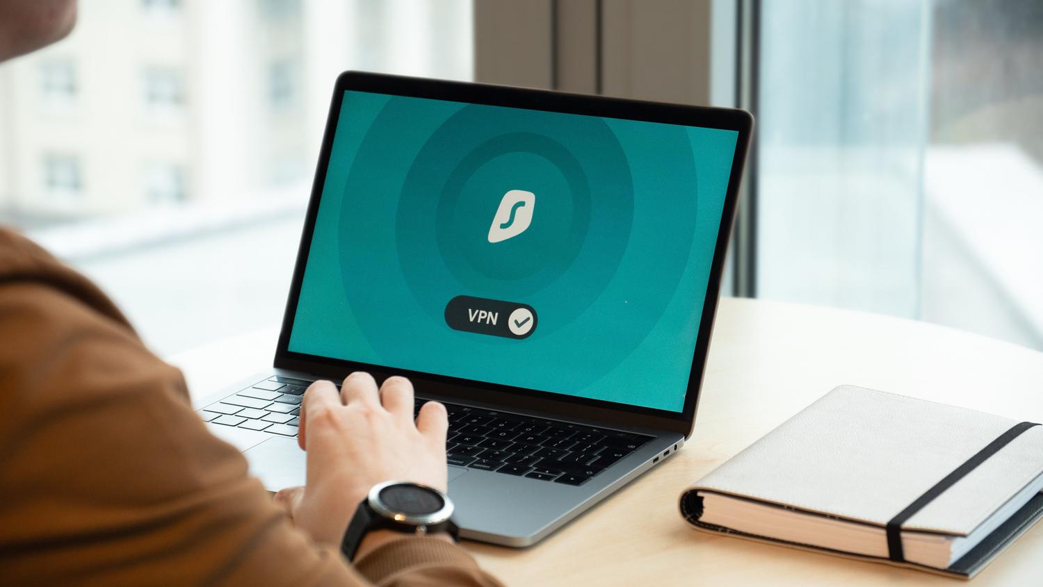 Profesional utilizando una conexión VPN en su portátil dentro de una oficina moderna para asegurar sus datos.