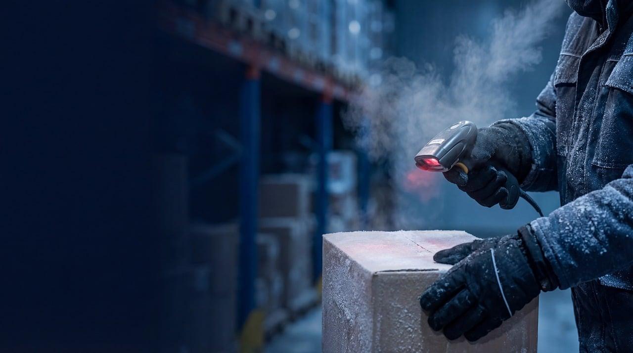 Escaneo láser de etiquetas en un almacén logístico, representando la captura de datos necesaria para la inteligencia artificial.