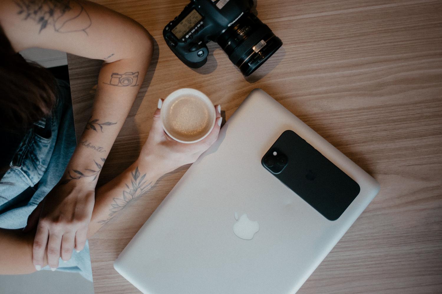 Espacio de trabajo portátil con MacBook y cámara profesional, ideal para edición móvil y portabilidad