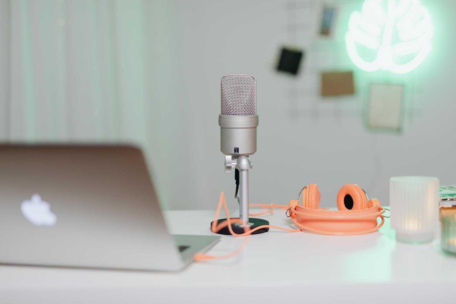 Escritorio moderno con equipo de audio profesional, micrófono y portátil