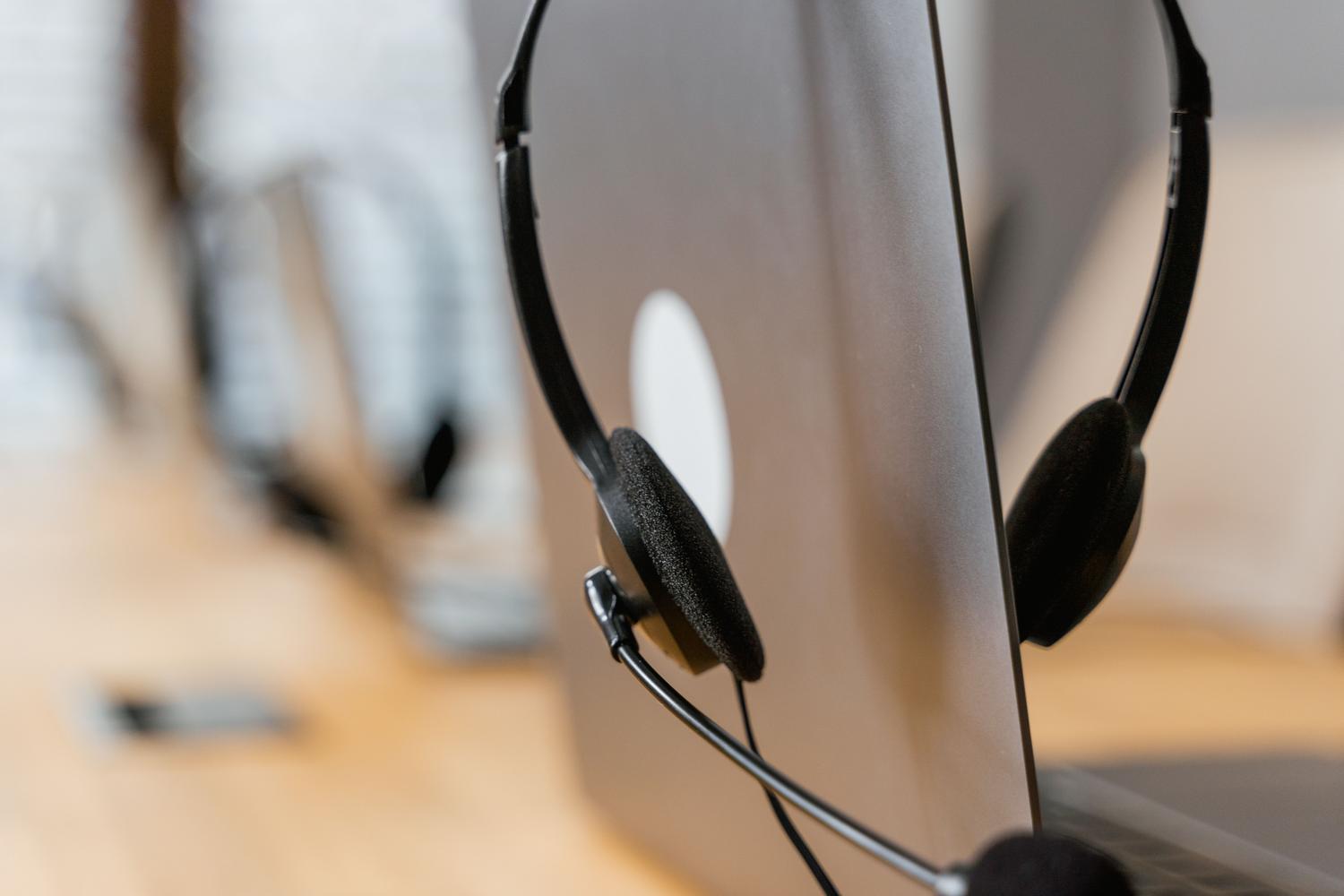Auriculares con micrófono sobre un portátil en un entorno de trabajo minimalista
