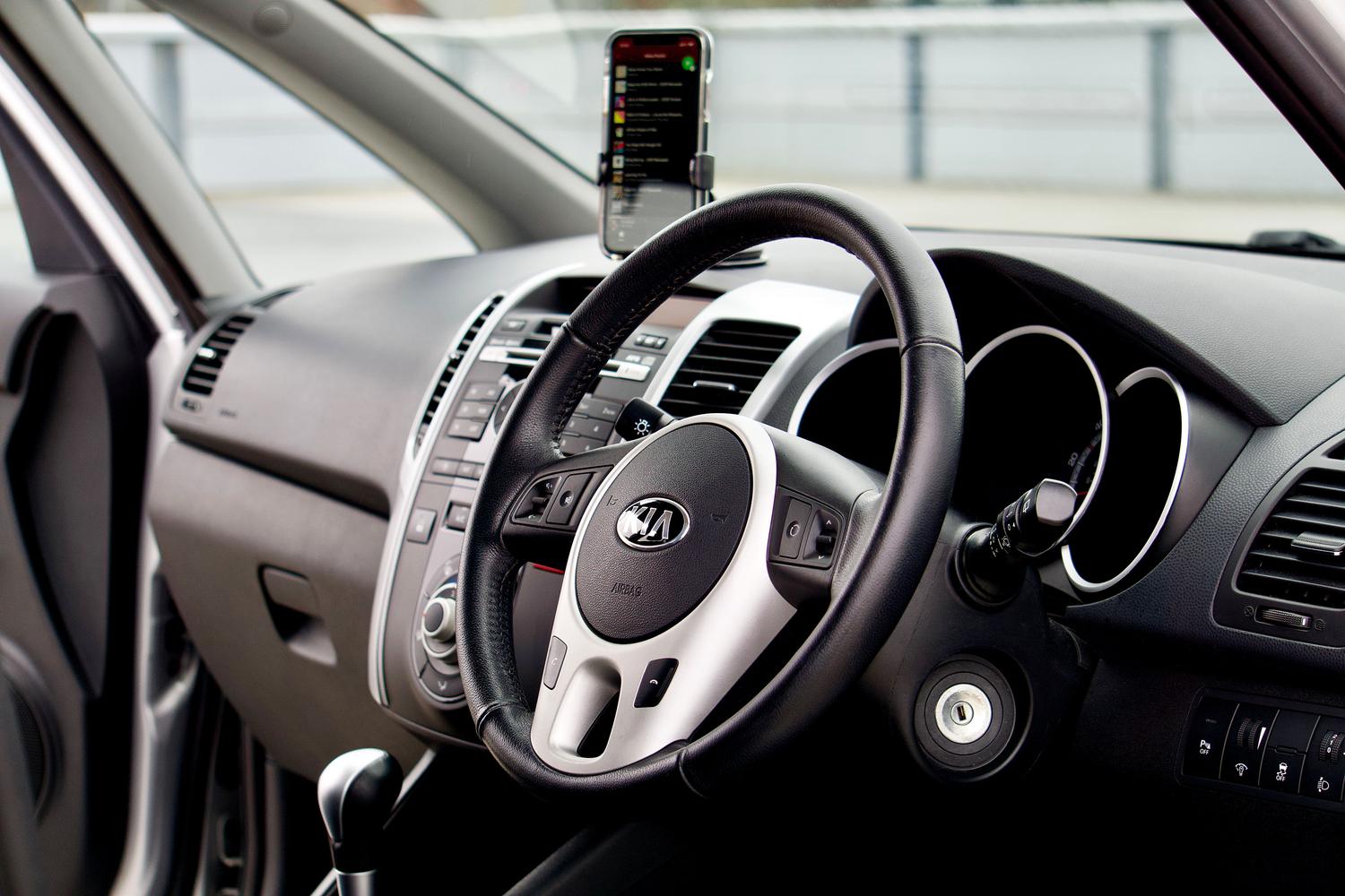 Vista del interior de un coche moderno con un soporte para smartphone integrado en el diseño del salpicadero.