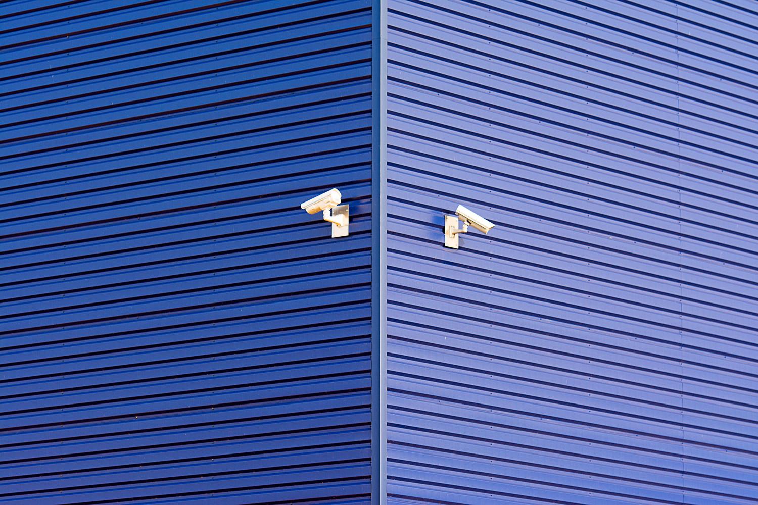 Cámaras de seguridad modernas sobre fondo azul, representando la infraestructura de videovigilancia IP.