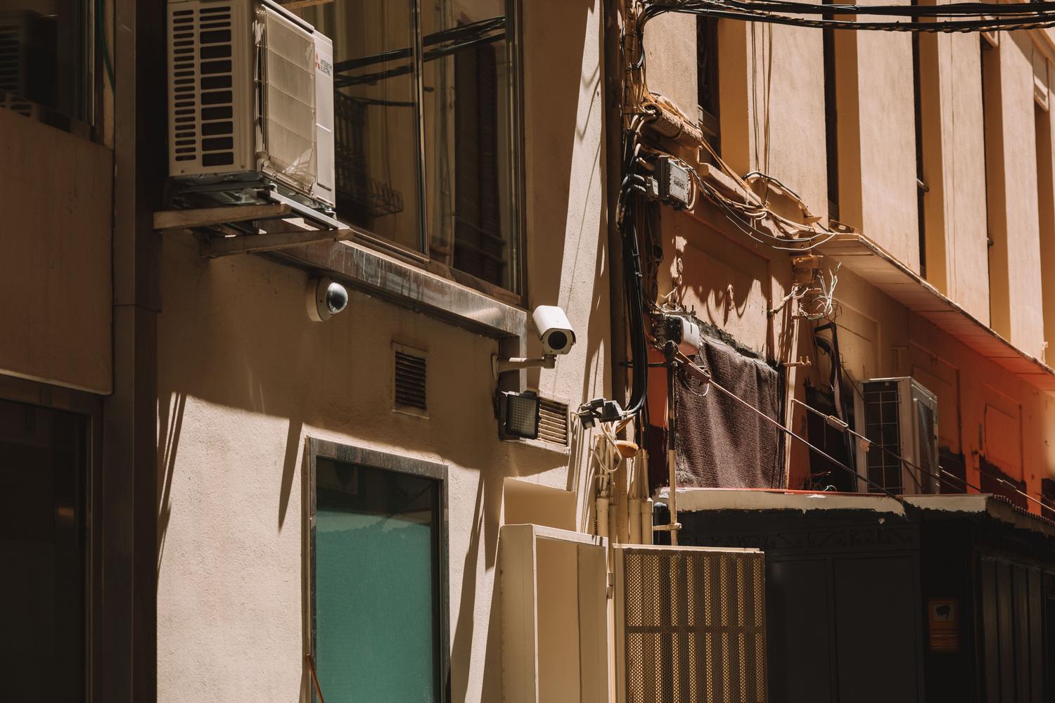 Instalación de cámaras urbanas con cableado expuesto, simbolizando una amplia superficie de ataque y falta de mantenimiento.