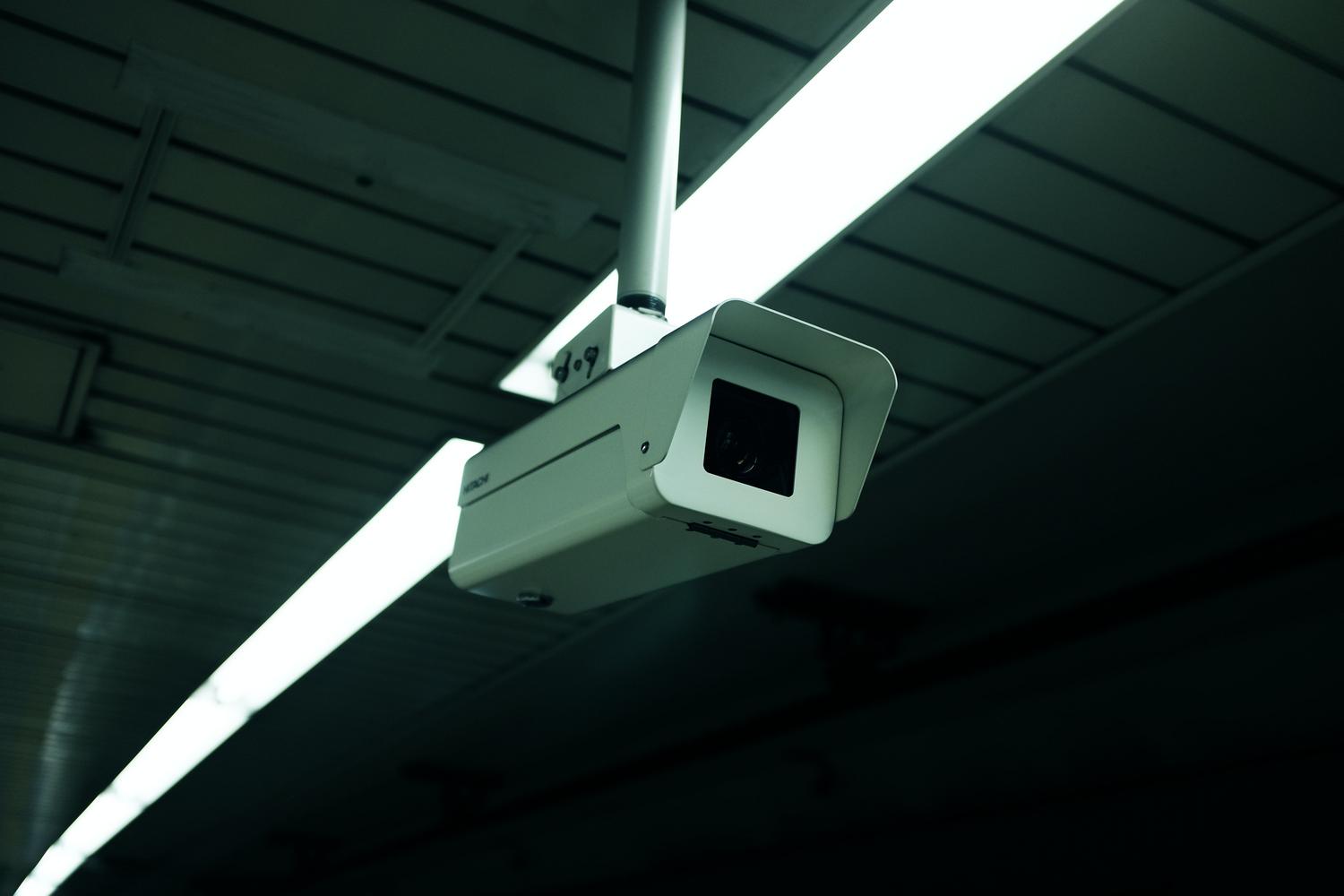 Vista contrapicada de una cámara de seguridad interior, evocando la pérdida de privacidad por accesos no autorizados.