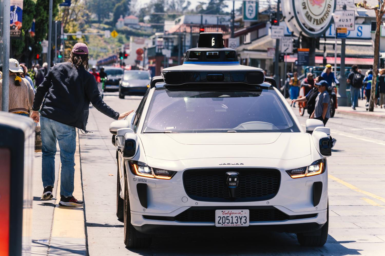 Un vehículo autónomo (robotaxi) navegando por una calle concurrida, ilustrando la integración de la movilidad automatizada en la ciudad.