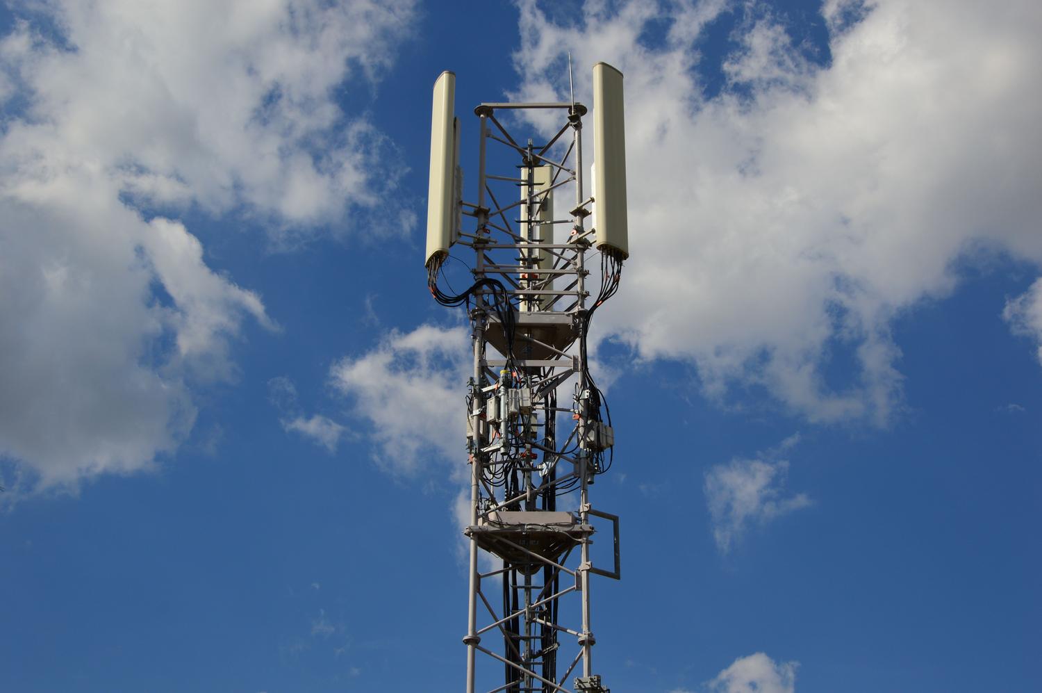 Torre de comunicación celular bajo un cielo azul, ilustrando la infraestructura básica y el funcionamiento de las antenas 5G.