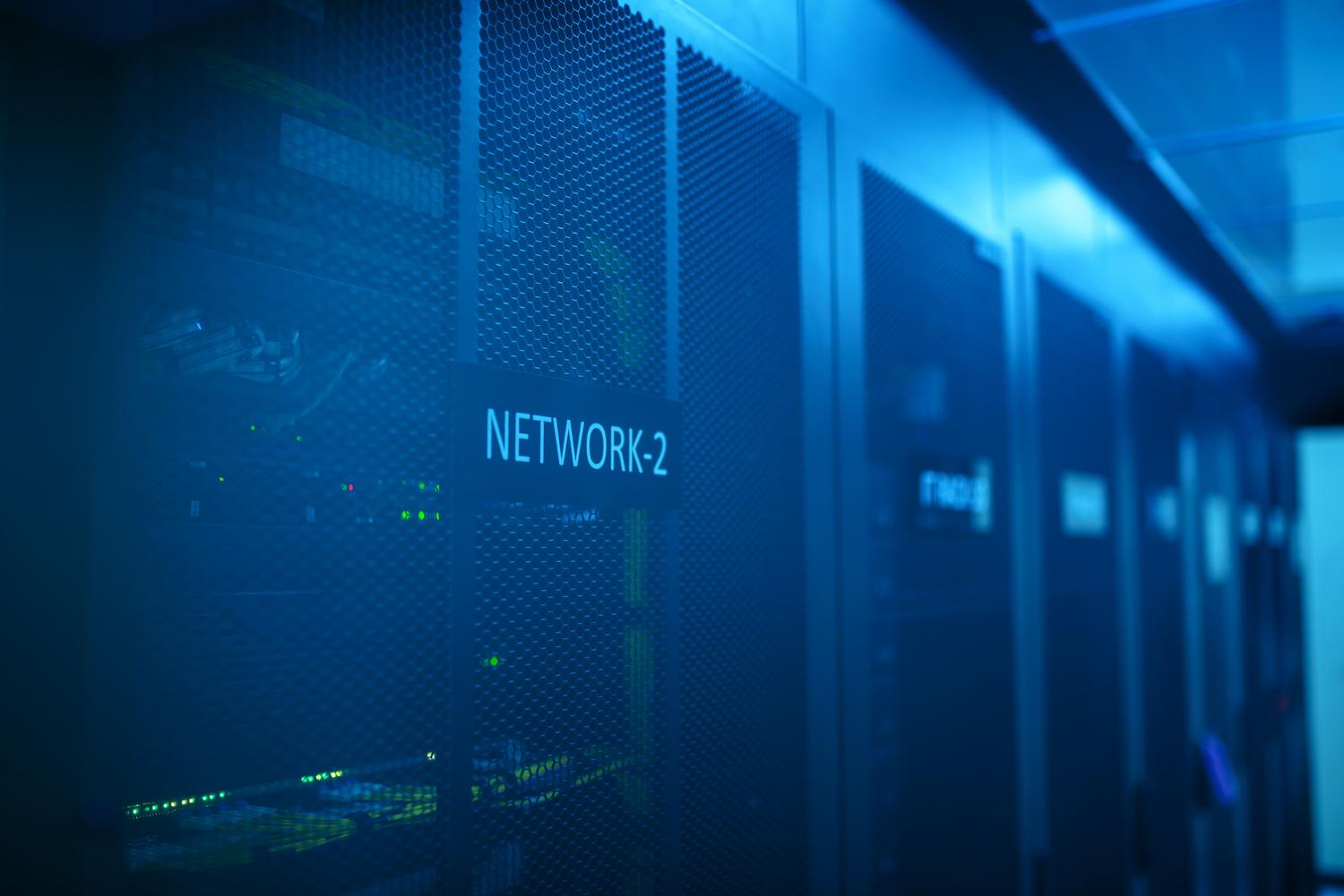 Sala de servidores moderna con equipos de red iluminados en azul, ideal para representar el network slicing y la ciberseguridad.